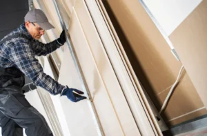 Pre-drywall wall framing and rough-ins being checked before drywall installation